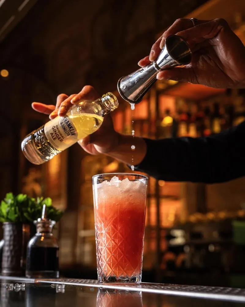 A cocktail being poured at the 709 bar, bottle and shaker in hand