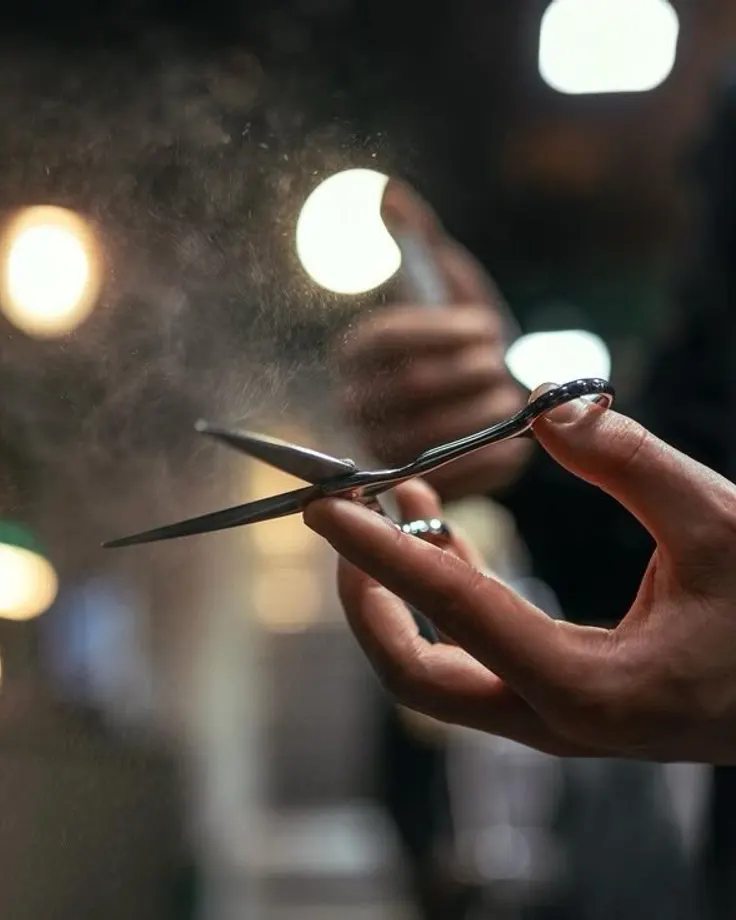 Barber's shears held open against the lounge lights